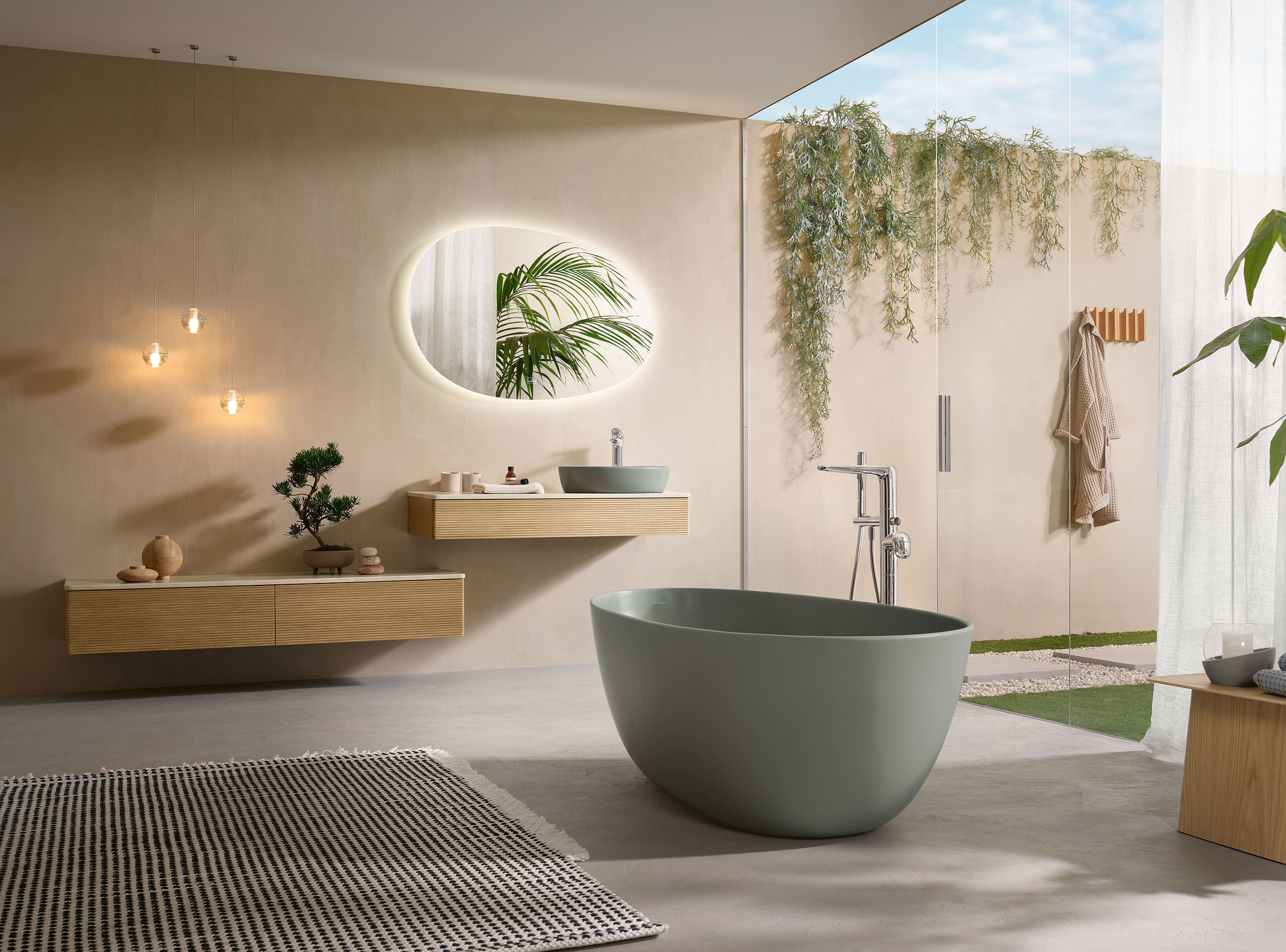 A modern bathroom with a green bath from the Antao collection and coordinating wood-look furniture.