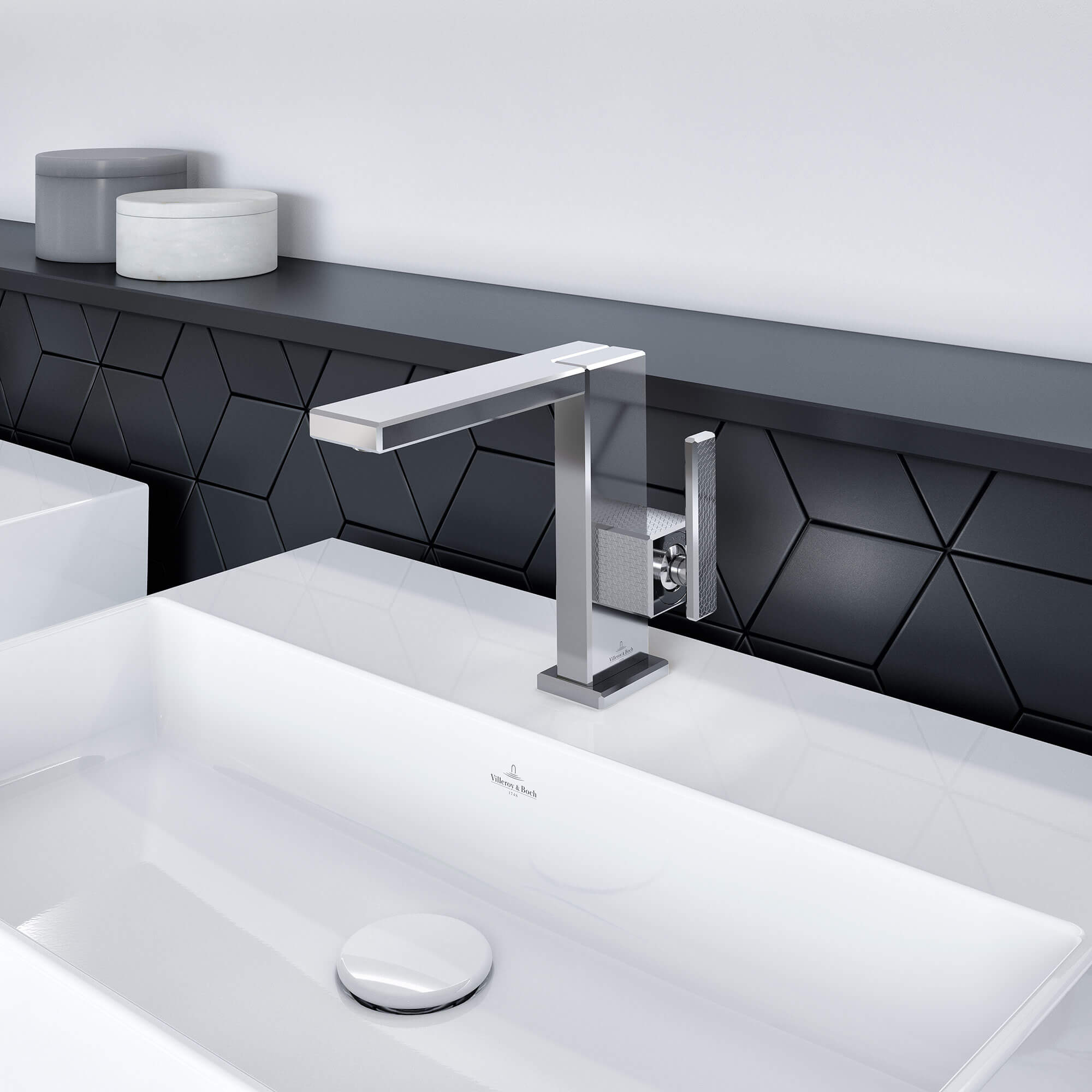 Modernes Waschbecken mit quadratischem Metallhahn, weißer Arbeitsplatte und schwarzer geometrischer Aufkantung.